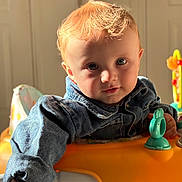 Edzio a rejoint le concours — aidez-le/la à gagner de superbes lots ! activity_center, baby, blue_eyes, child, close_up, curious_expression, cute, denim_jacket, face, indoor, natural_light, orange_tray, playtime, portrait, red_hair, seat, sunlight, teal_toy, toddler, toy