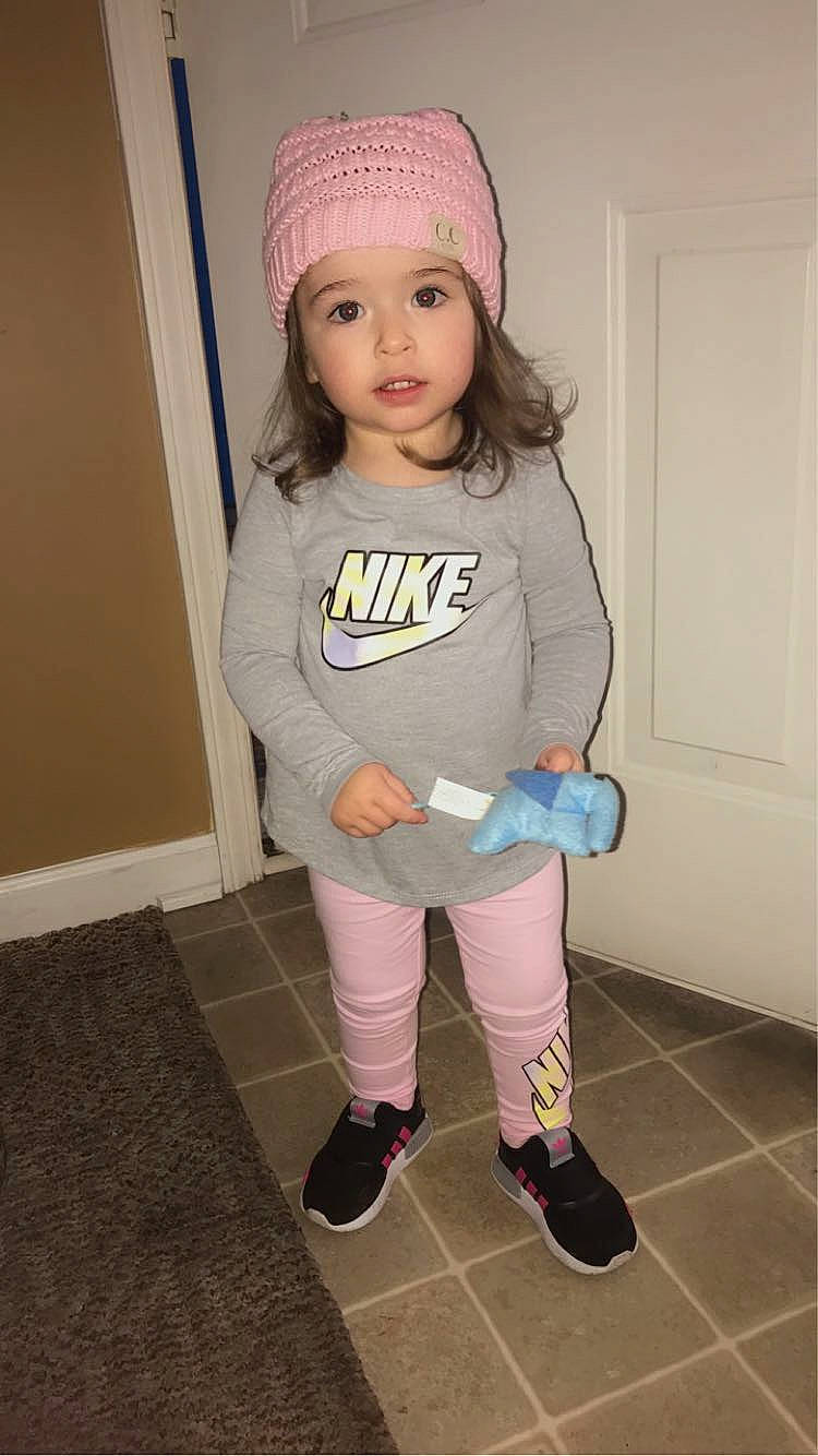 Myla is registered to the contest to win money with this photo: baby_toddler_clothing, cap, child, clothing, door, face, fashion_accessory, flooring, headwear, human_leg, knee, knit_cap, magenta, outerwear, pattern, person, pink, purple, sleeve, sock