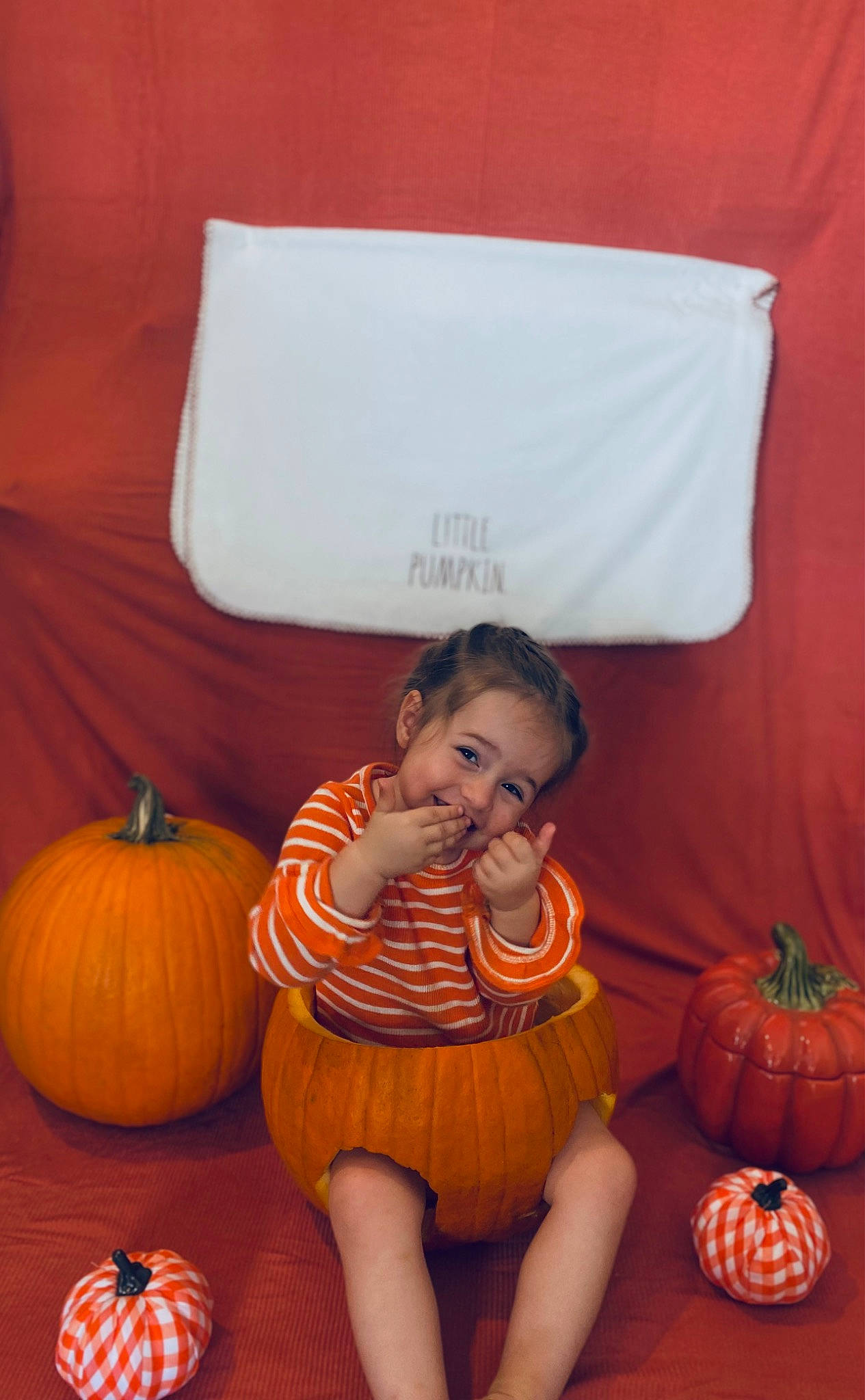 Lilah is registered to the contest to win money with this photo: calabaza, child, comfort, cucurbita, flooring, fun, gourd, happy, head, human_body, joy, natural_foods, orange, person, plant, pumpkin, sitting, squash, toddler, vegetable