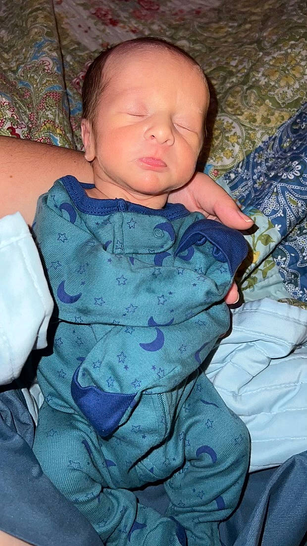 Walker is registered to the contest to win money with this photo: azure, baby, baby_toddler_clothing, cheek, chin, comfort, eye, hand, iris, linens, mouth, neck, nose, pattern, person, purple, skin, sleeve, textile, toddler