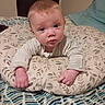 baby, infant, child, portrait, face, eyes, looking_at_camera, indoors, bedroom, bed, cushion, pillow, blanket, sweater, clothing, sitting, relaxed, floral_pattern, home, photography