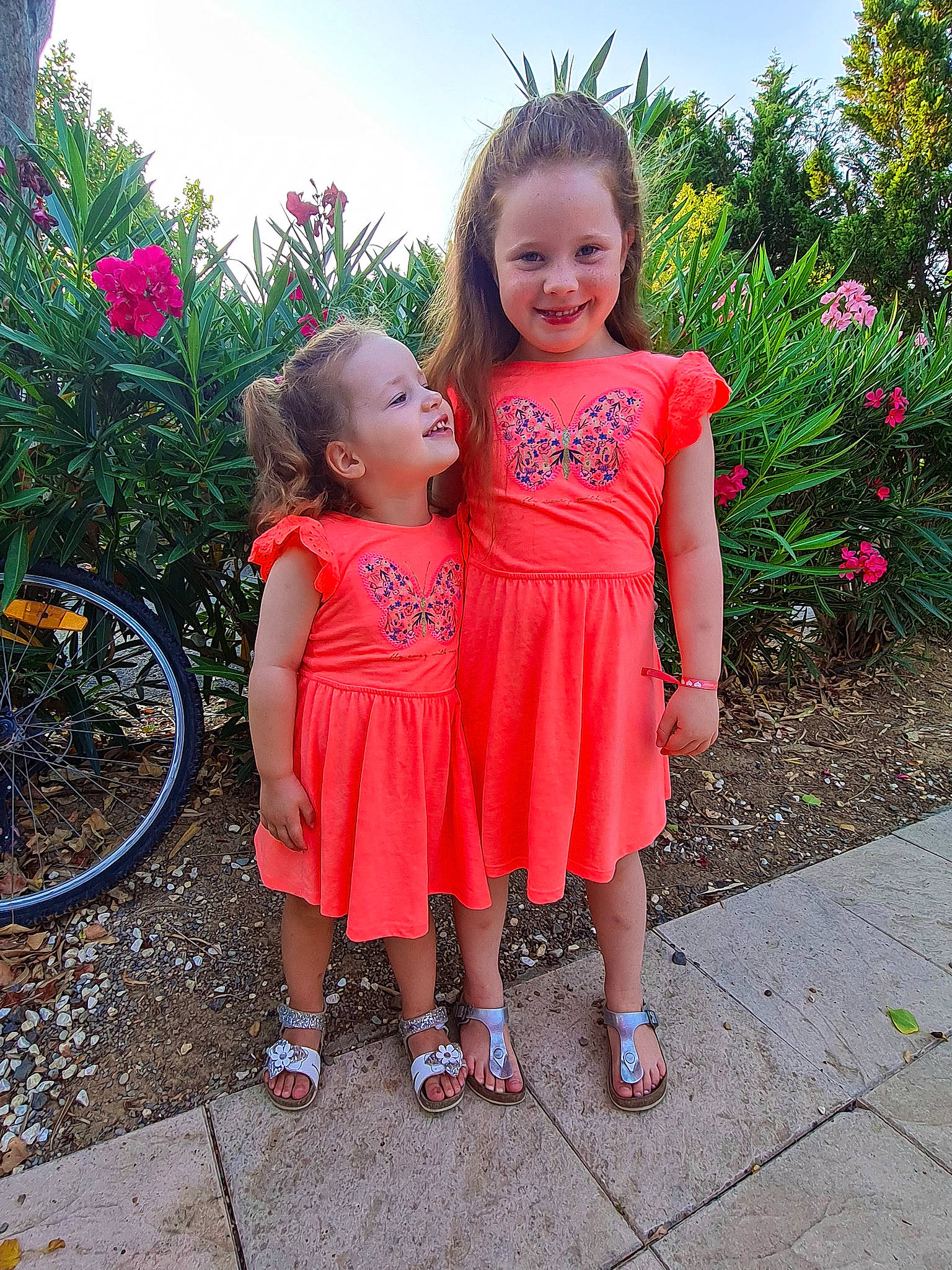 Chloé participe au concours pour gagner de l'argent avec cette photo : bicycle, bicycle_wheel, bicycles_equipment_and_supplies, dress, eye, grass, hair, happy, head, human_body, iris, joy, people_in_nature, person, pink, plant, skin, sky, smile, tire