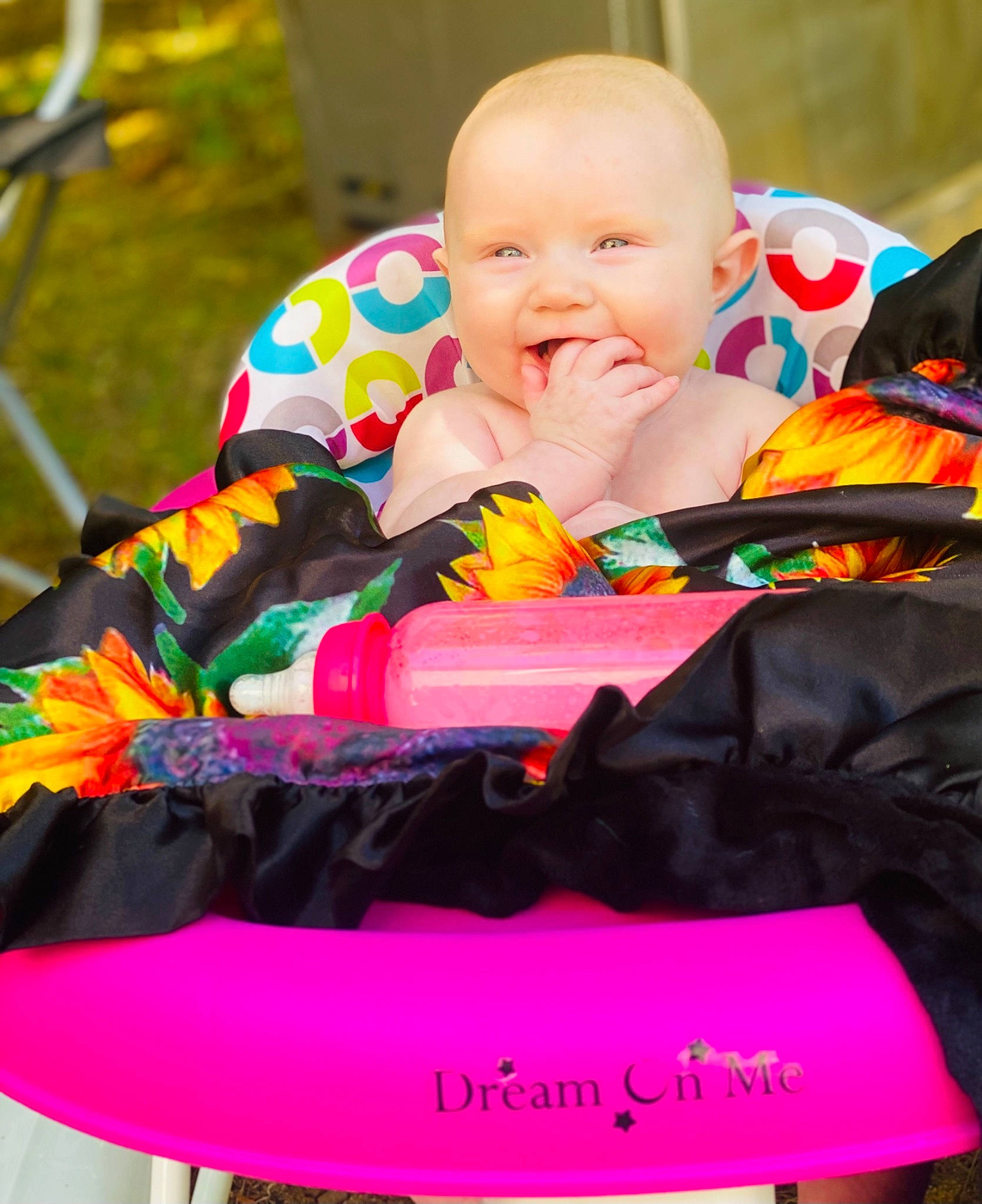 Carly is registered to the contest to win money with this photo: baby, baby_products, baby_toddler_clothing, chair, child, comfort, event, face, fun, grass, happy, lap, leisure, linens, magenta, person, photograph, pink, play, sitting