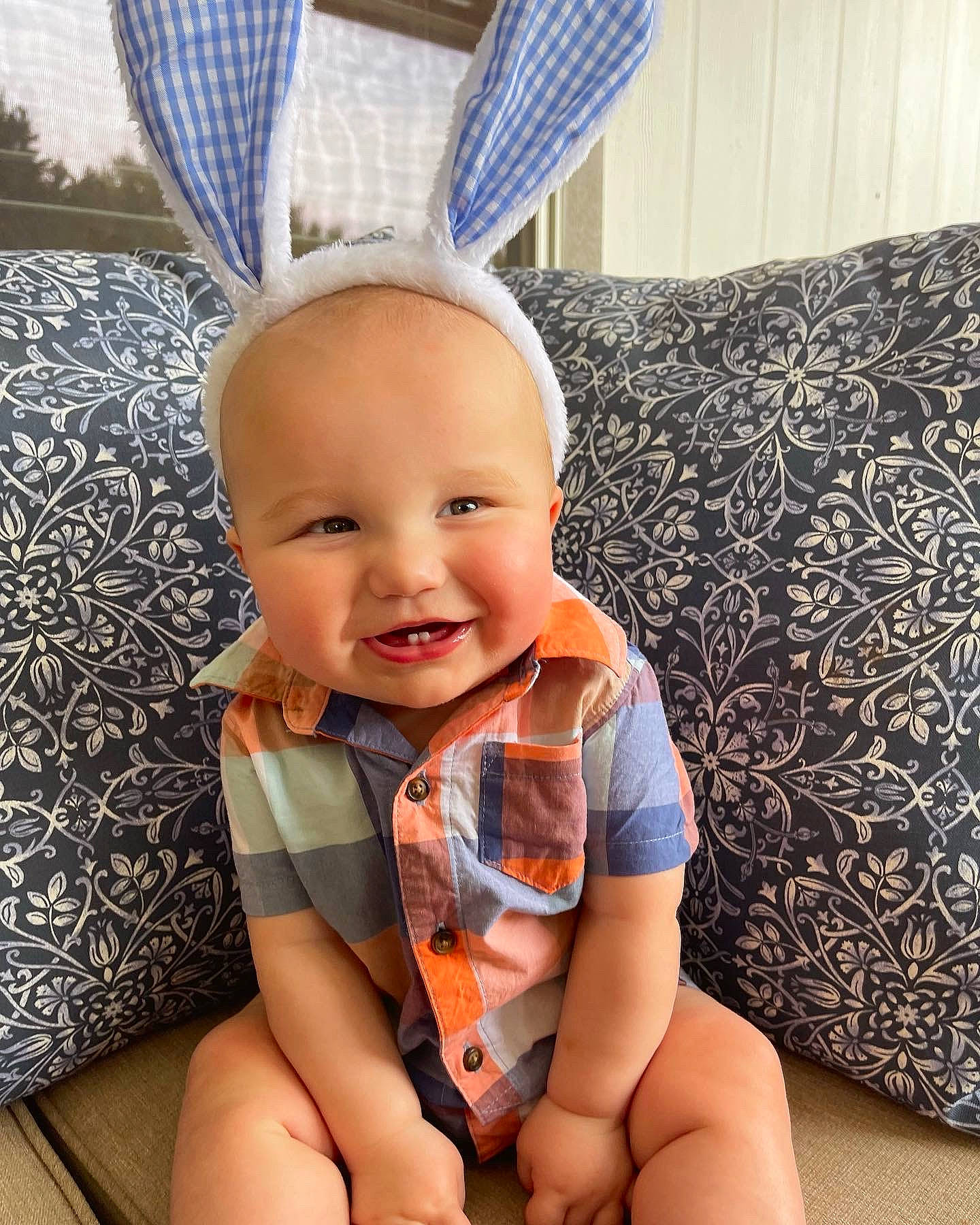 Graham is registered to the contest to win money with this photo: baby, baby_toddler_clothing, blue, child, comfort, couch, elbow, eye, happy, hat, human_leg, knee, pattern, person, rabbits_and_hares, sleeve, smile, textile, thigh, toddler