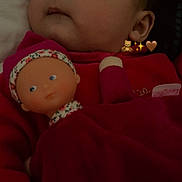 Aleïa a rejoint le concours — aidez-le/la à gagner de superbes lots ! baby, doll, child, red_clothing, portrait, face, closeup, indoor, soft_lighting, expression, toy, cute, infant, headwear, person, sleepwear, cozy, looking_away, plush, young_child