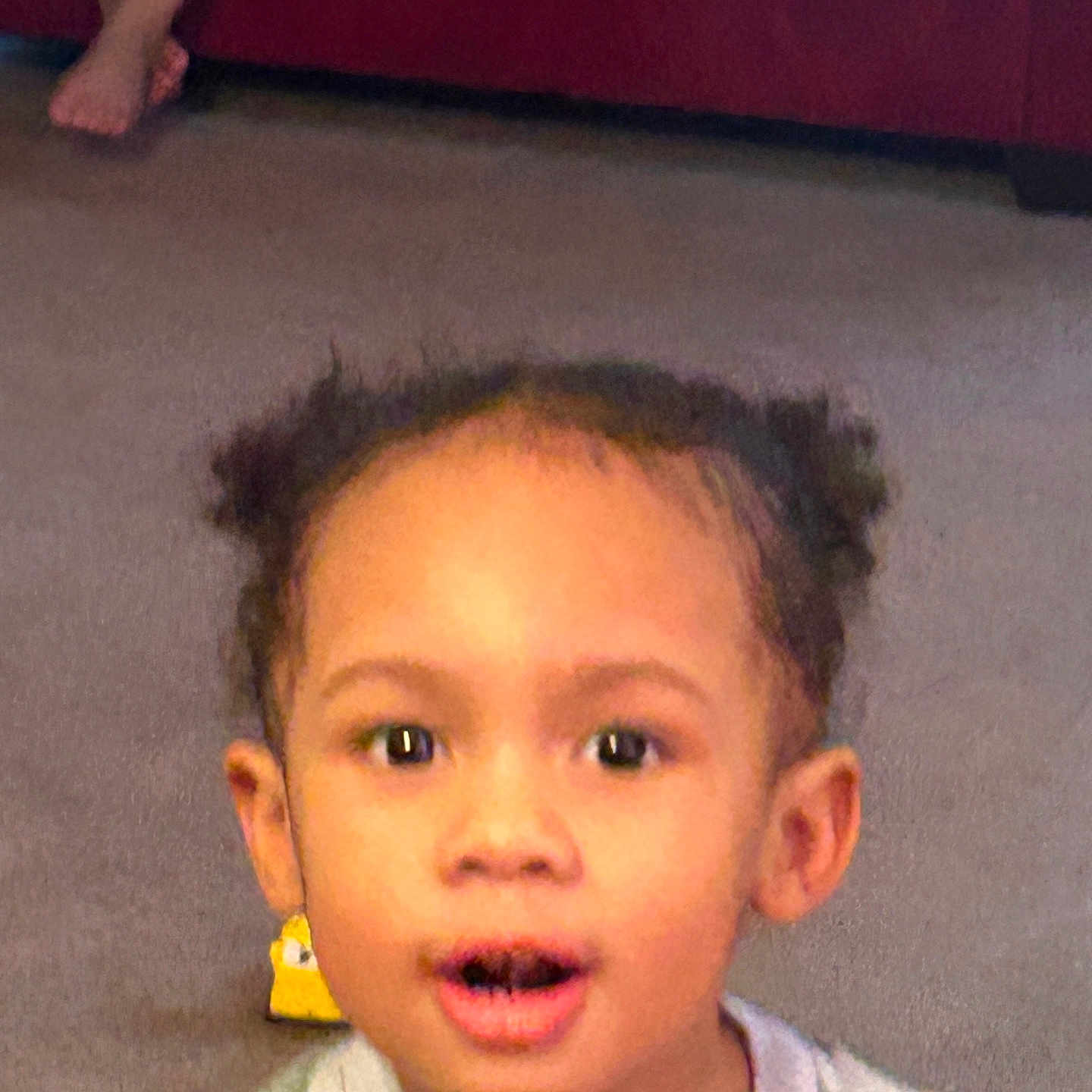 Ivanni joined the competition — help win amazing prizes! bare_foot, carpet, child, clothing, couch, ears, expression, eyes, face, hair_puffs, indoor, living_room, open_mouth, person, portrait, smiling_ish, surprised, toddler, toy, young_child