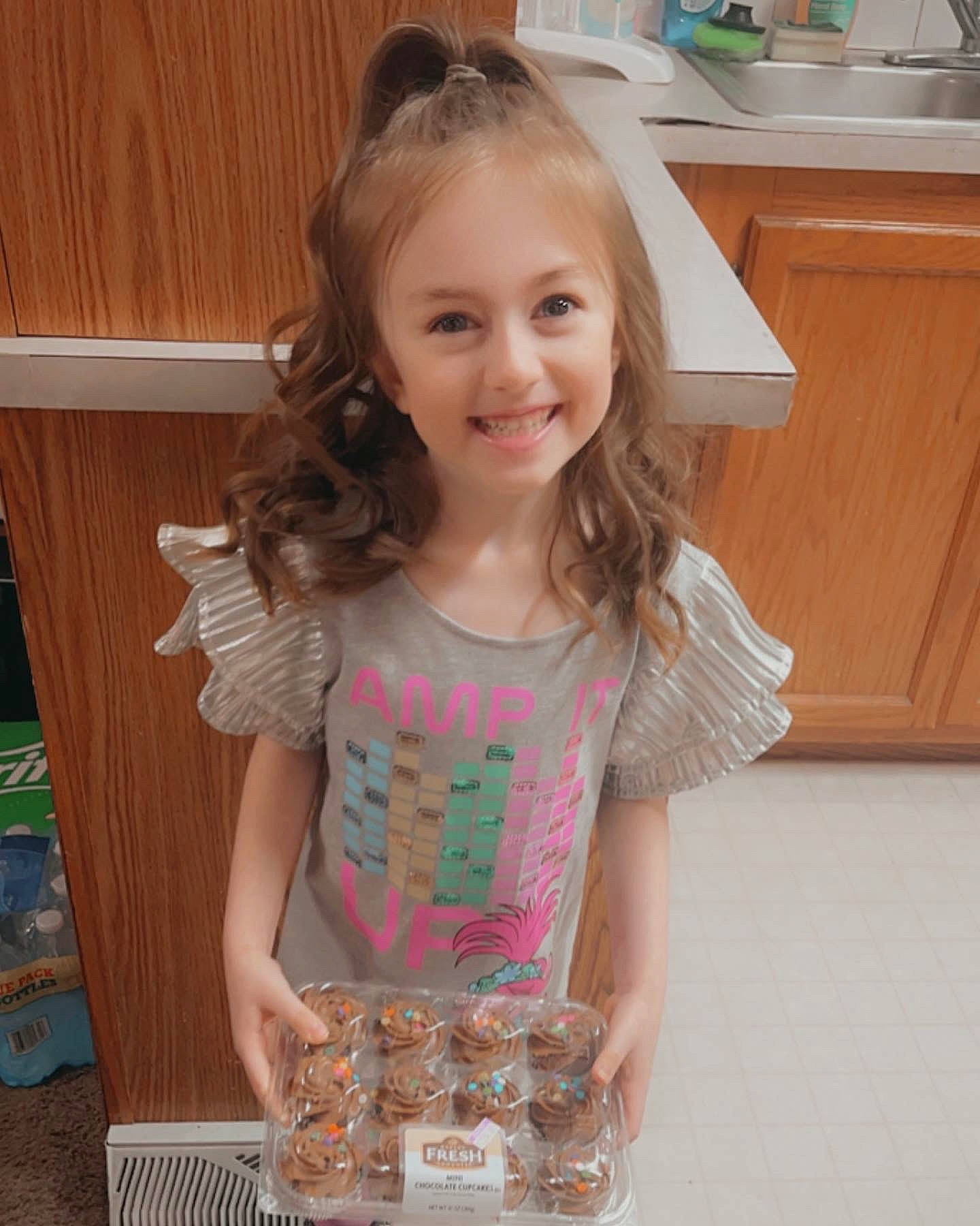 Lillian is registered to the contest to win money with this photo: blond, brown_hair, child, countertop, face, flooring, fun, hair, happy, hardwood, head, joy, long_hair, mammal, pattern, person, sleeve, smile, t_shirt, toddler