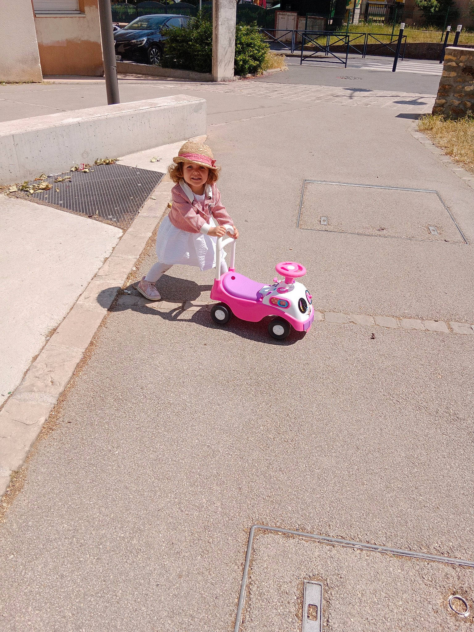 Lena a rejoint le concours — aidez-le/la à gagner de superbes lots ! asphalt, automotive_design, automotive_wheel_system, dress, flooring, grass, headwear, joy, leisure, motor_vehicle, person, plant, recreation, riding_toy, road, road_surface, rolling, sidewalk, tire, toddler