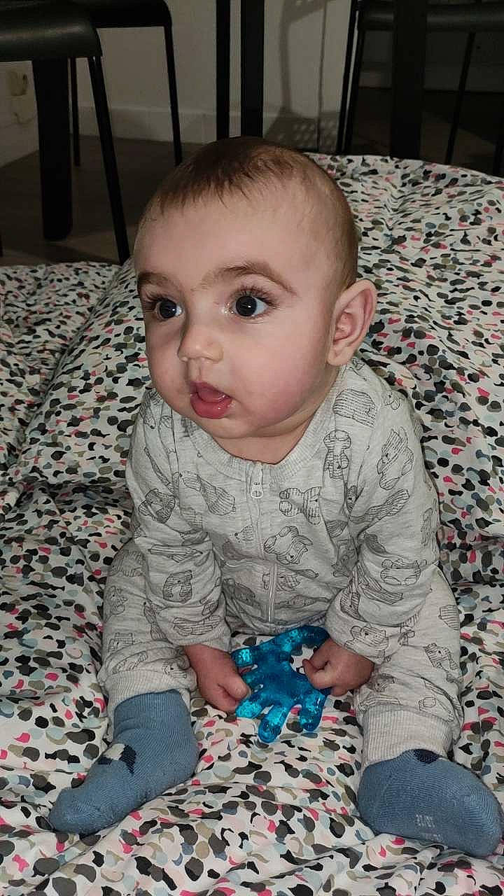 Thao participe au concours pour gagner de l'argent avec cette photo : baby, baby_toddler_clothing, cheek, child, comfort, electric_blue, eye, face, flooring, head, iris, nose, pattern, people, person, product, sitting, skin, sleeve, t_shirt