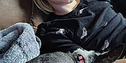 Kari Ann is registered to the contest to win money with this photo: child, dog, couch, blanket, smile, resting, indoor, cozy, pet, fur, collar, relaxation, happy, comfort, leisure, person, portrait, casual, home, snuggle