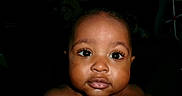 Tymir is registered to the contest to win money with this photo: alert, baby, centered_composition, child, close_up, cute, dark_background, eyes, face, flash_photography, hair, head, indoor, infant, looking_at_camera, photograph, portrait, shoulders, skin, wide_eyed