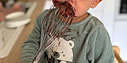 Loan a rejoint le concours — aidez-le/la à gagner de superbes lots ! toddler, child, chocolate, whisk, kitchen, messy, face, hands, clothing, sweater, cute, brown_eyes, wooden_handle, smile, standing, indoor, food, baking, appliance, home