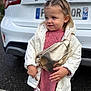 toddler, child, girl, white_jacket, pink_dress, gold_purse, pacifier, outdoor, car, ford, license_plate, parking_lot, cute, portrait, fashion, blond_hair, earrings, expression, standing, casual