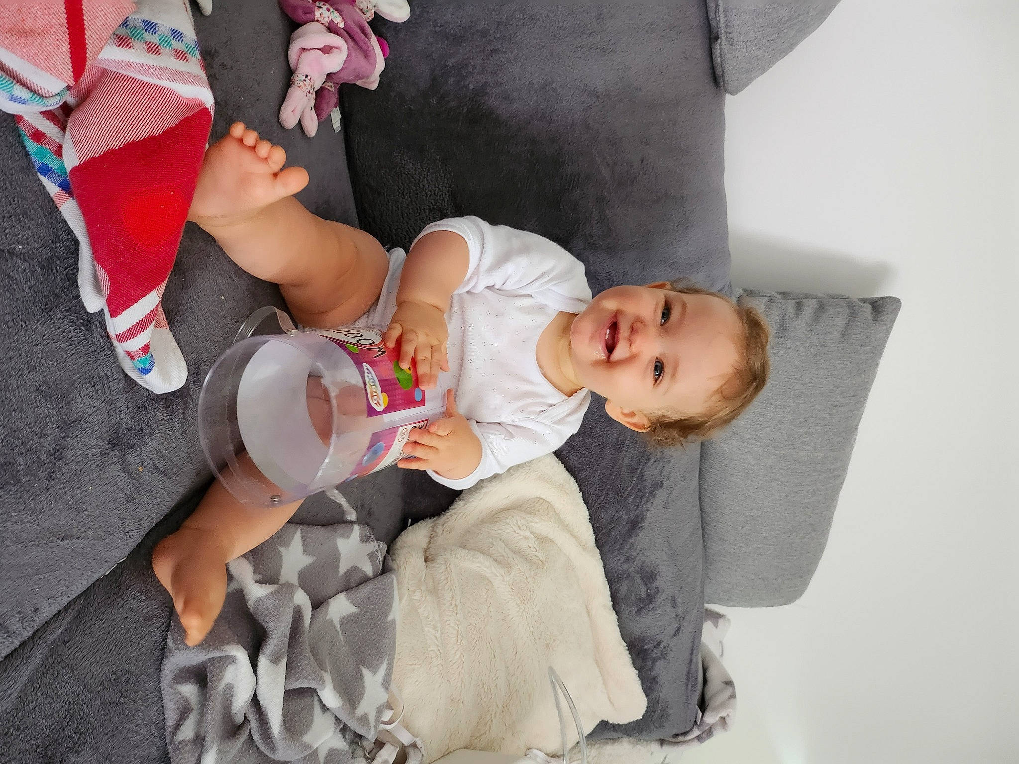 Emie participe au concours pour gagner de l'argent avec cette photo : arm, baby, baby_products, baby_toddler_clothing, carmine, child, comfort, event, fun, happy, hat, human_leg, joy, leg, person, room, sitting, sleeve, smile, sock