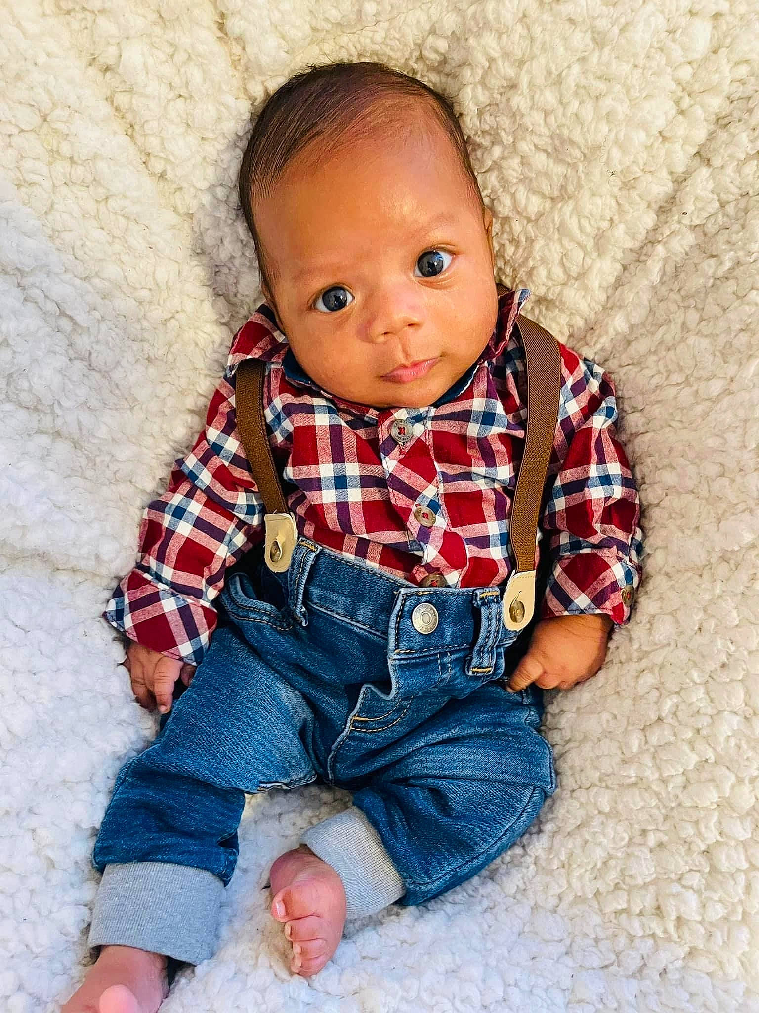 Osiah is registered to the contest to win money with this photo: arm, baby, baby_toddler_clothing, child, chin, collar, comfort, denim, dress_shirt, electric_blue, eye, pattern, person, plaid, shirt, skin, sleeve, tartan, textile, tie
