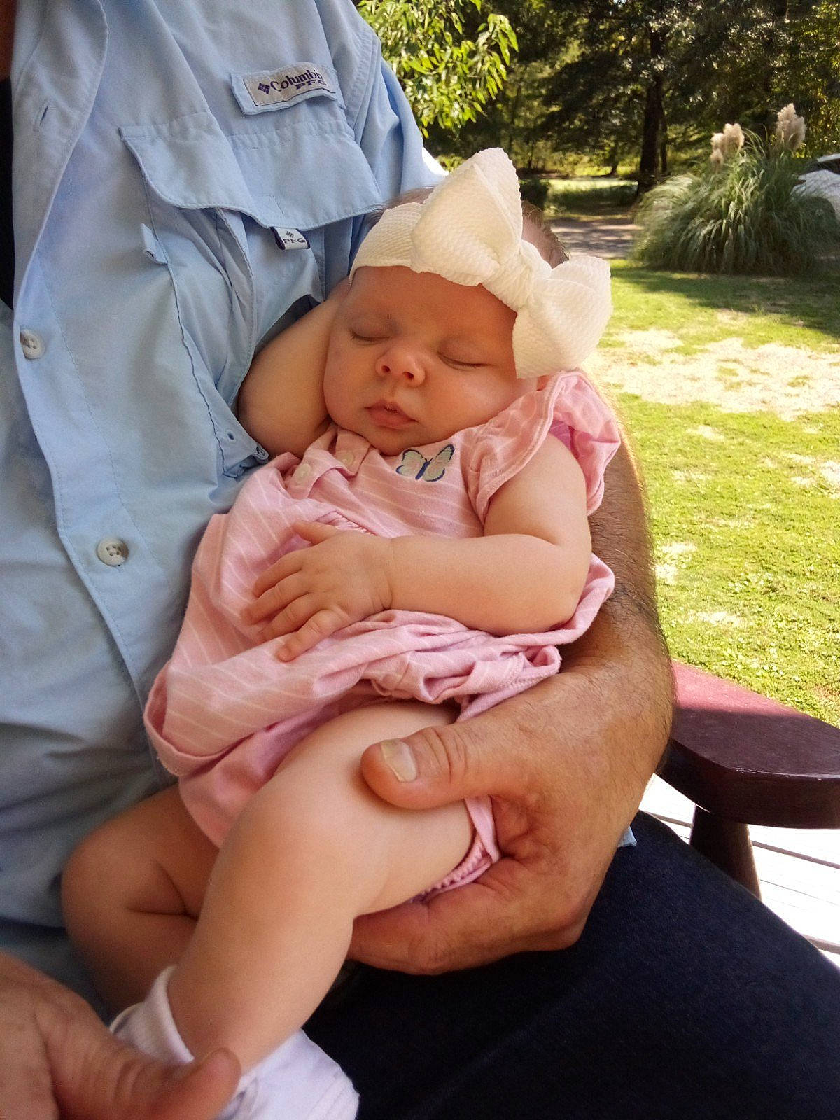 Makenna joined the competition — help win amazing prizes! baby, baby_products, baby_toddler_clothing, child, comfort, finger, gesture, grass, hand, hat, headwear, lap, person, pink, plant, sitting, skin, sun_hat, thigh, thumb