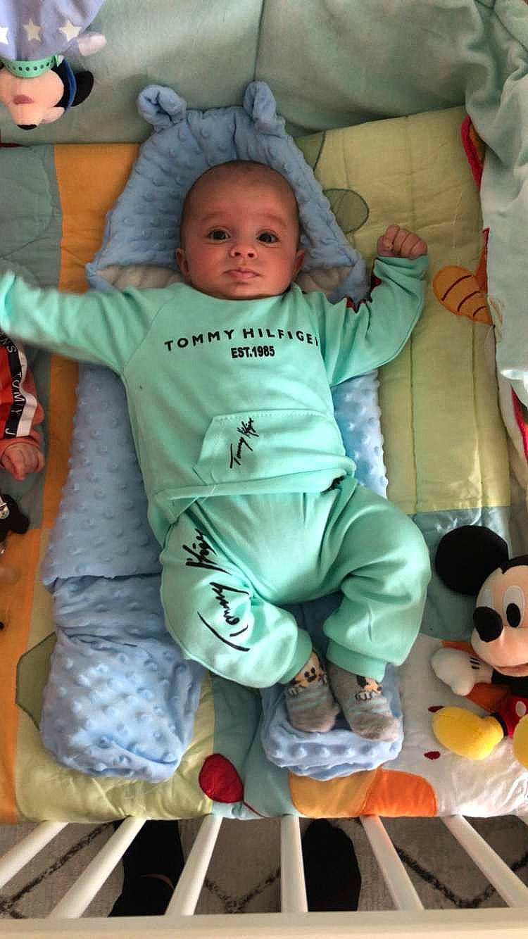 Benyamin a rejoint le concours — aidez-le/la à gagner de superbes lots ! baby, baby_toddler_clothing, cheek, child, comfort, eye, fun, gesture, happy, linens, people, person, sitting, skin, sleeve, smile, snapshot, sock, thumb, toddler