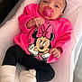 Rym a rejoint le concours — aidez-le/la à gagner de superbes lots ! baby, infant, pacifier, pink_sweatshirt, minnie_mouse, black_pants, white_socks, cushioned_surface, indoor, portrait, child, cute, comfort, cozy, clothing, sitting, resting, young_child, face, person
