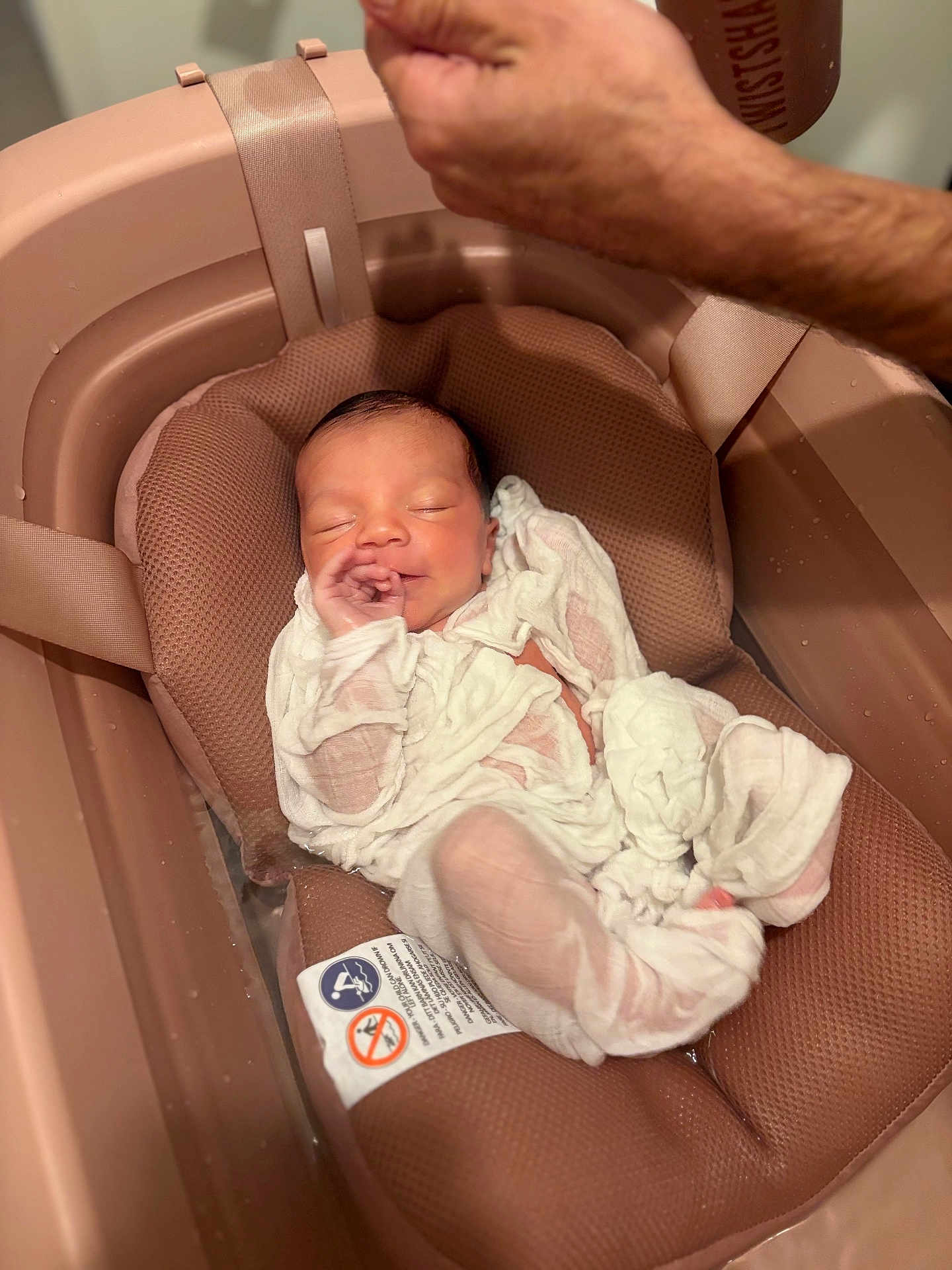 Rym participe au concours pour gagner de l'argent avec cette photo : newborn, baby, infant, sleeping, bath, baby_bath, baby_seat, white_clothing, cushion, hand, adult_hand, soft_texture, closeup, indoors, peaceful, resting, skin, newborn_clothes, baby_care, parenting