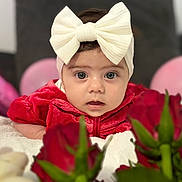 Sofia participe au concours pour gagner de l'argent avec cette photo : baby, child, face, headband, bow, red_clothing, roses, flower, blanket, balloon, portrait, cute, indoors, closeup, soft_texture, infant, curious, decor, celebration, young_child
