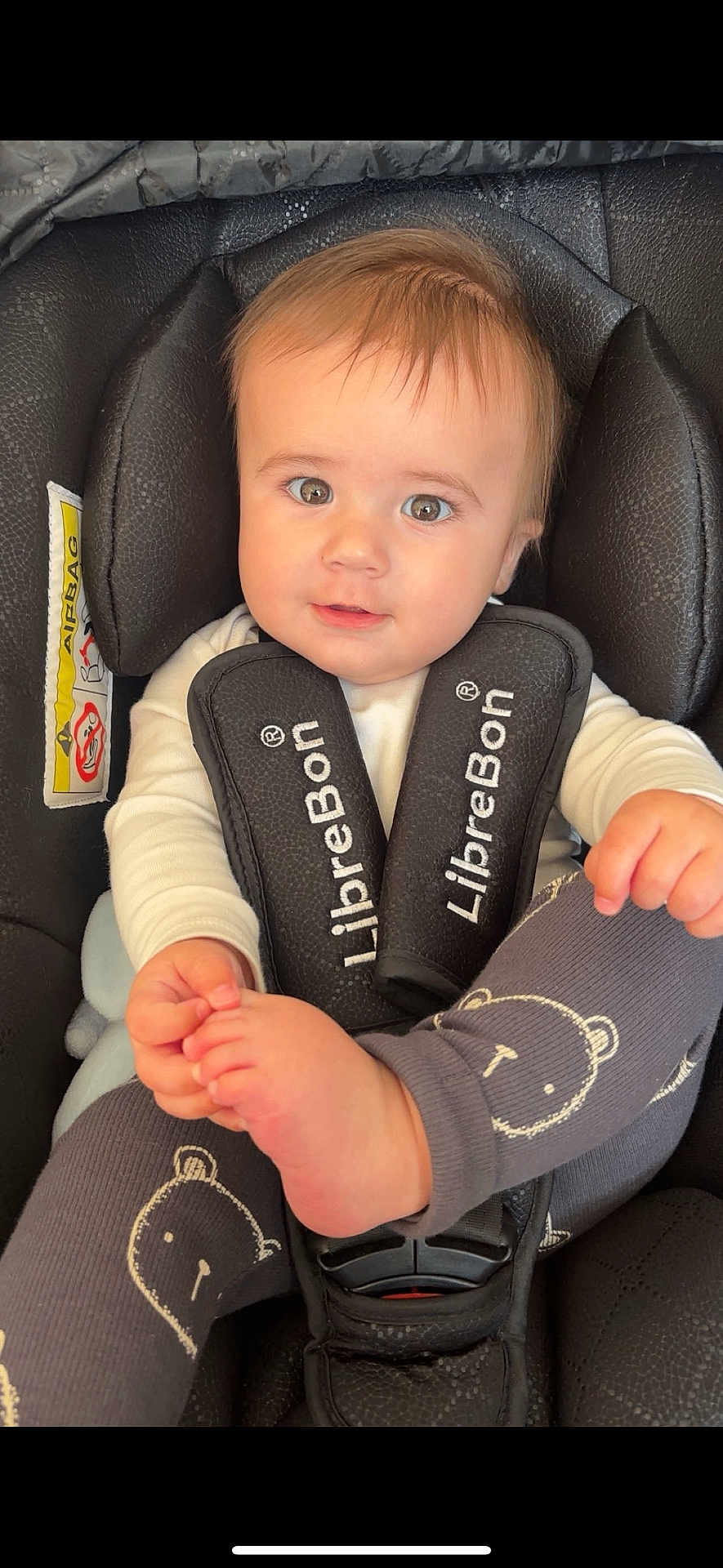 Oscar joined the competition — help win amazing prizes! baby, child, car_seat, infant, face, eyes, clothing, white_shirt, leggings, bear_pattern, foot, hand, hair, seat_belt, black, safety, cute, portrait, indoor, closeup
