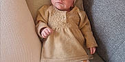 Victoria participe au concours pour gagner de l'argent avec cette photo : baby, infant, couch, pillow, headband, slippers, bear_slippers, clothing, leggings, sitting, indoor, portrait, cute, expression, face, small_child, soft_furniture, cozy, neutral_colors, child
