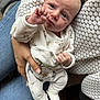 Victoria participe au concours pour gagner de l'argent avec cette photo : baby, infant, person, hand, clothing, jeans, sweater, knitwear, footwear, sock, couch, blanket, texture, face, indoor, holding, looking, cute, small, newborn