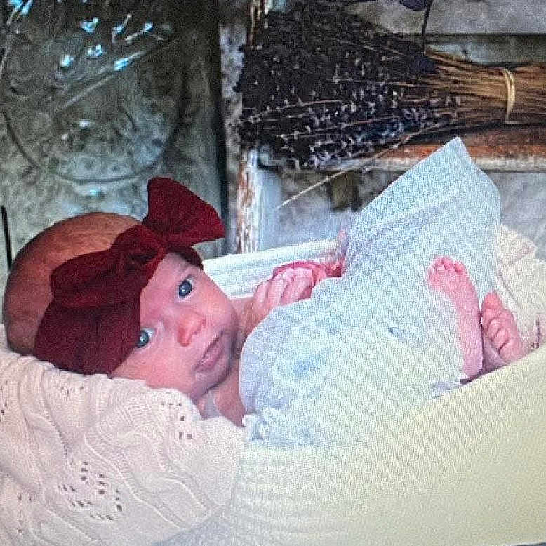 Ari joined the competition — help win amazing prizes! baby, bow, blanket, basket, blue, brown, cozy, face, headwear, infant, knitted, lying_down, person, portrait, resting, soft_texture, wood, wrapping, young_child, indoors
