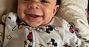 Jyaire joined the competition — help win amazing prizes! baby, beaded_necklace, beads, child, closeup, clothing, cute, face, happy, indoors, infant, joyful, lying_down, mickey_mouse, onesie, patterned, person, pillow, portrait, smiling