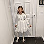 child, girl, white_dress, tights, pose, smile, indoor, door, floor, wall, long_hair, standing, happy, young, person, portrait, home, fashion, full_body, light