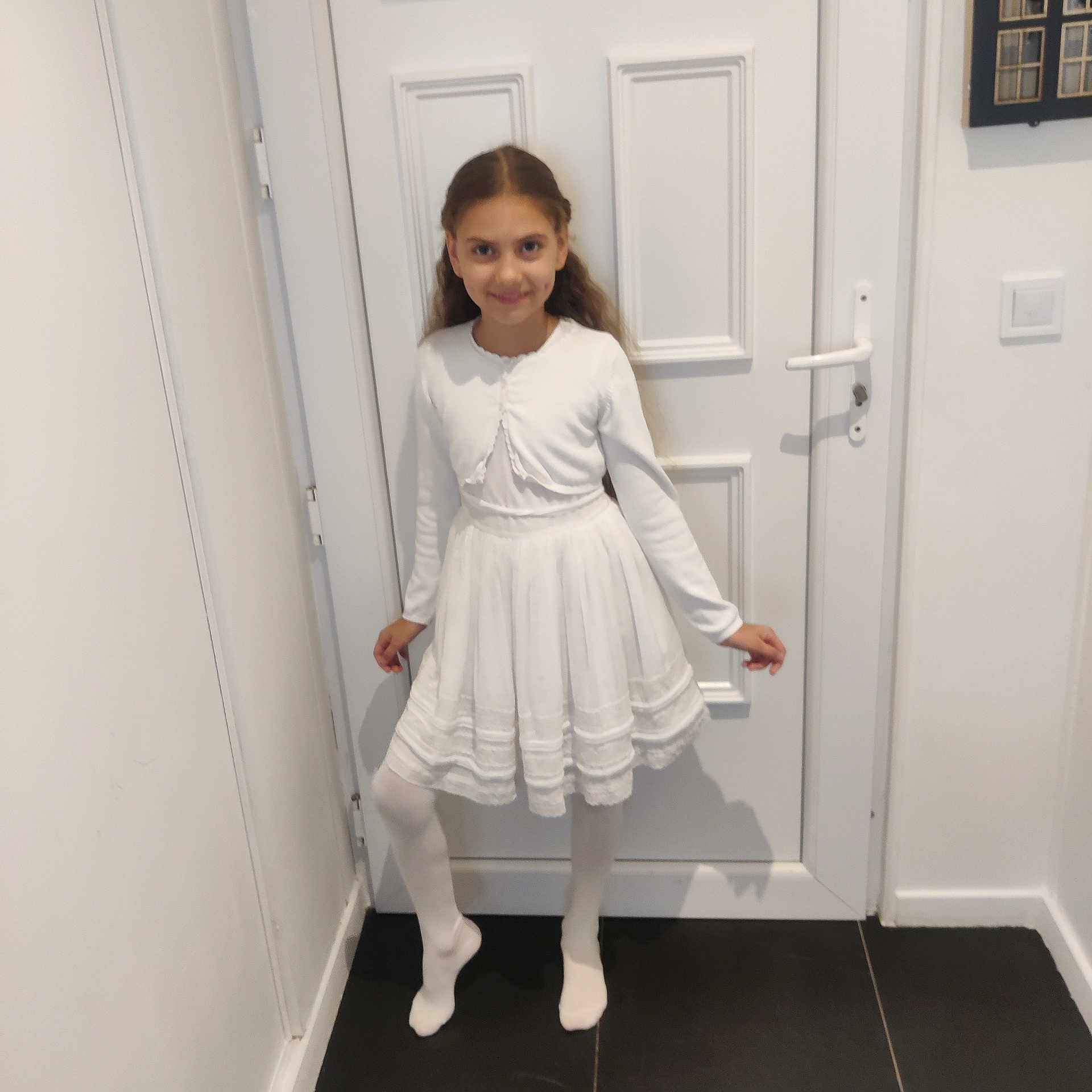 Renata a rejoint le concours — aidez-le/la à gagner de superbes lots ! child, girl, white_dress, tights, pose, smile, indoor, door, floor, wall, long_hair, standing, happy, young, person, portrait, home, fashion, full_body, light