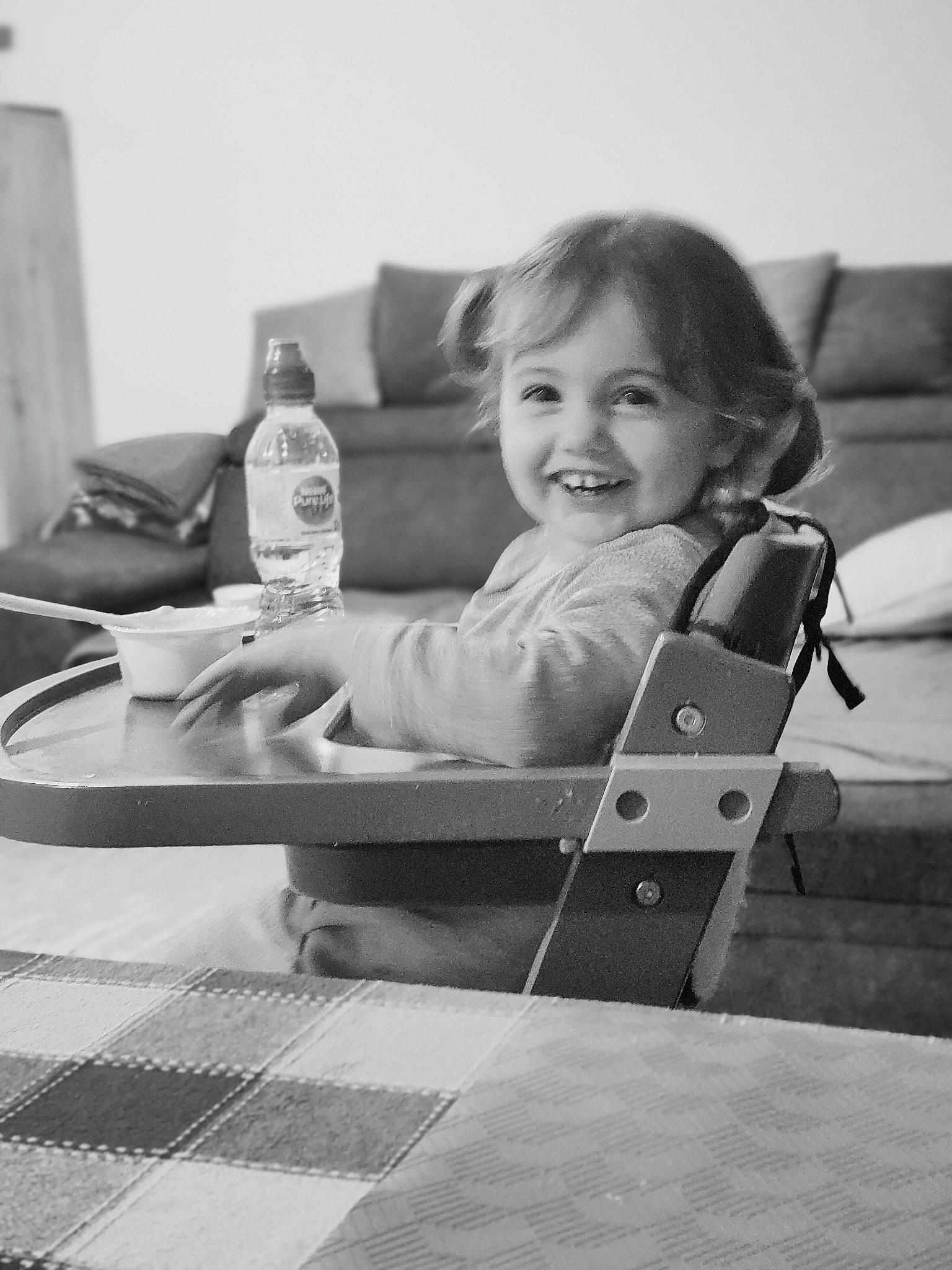 Kataleya participe au concours pour gagner de l'argent avec cette photo : arm, baby, black_and_white, bottle, child, comfort, drinkware, finger, hand, happy, human_body, joy, monochrome, monochrome_photography, person, photograph, smile, standing, style, table