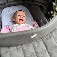 Lily joined the competition — help win amazing prizes! baby, stroller, blanket, smile, face, infant, happy, child, clothing, fabric, pattern, head, comfort, cushion, closeup, portrait, indoors, seat, baby_bedding, cozy