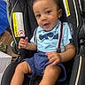 baby, black_car_seat, blue_clothing, bow_tie, car_seat, child, curly_hair, cute, feet, hands, happy, indoor, infant, legs, person, portrait, seat, smiling, suspenders, young_child