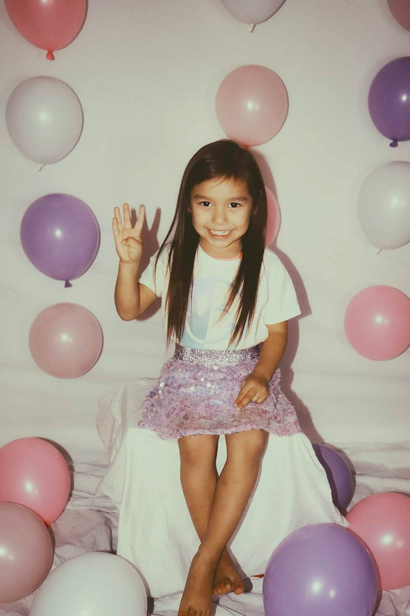 Marissa is registered to the contest to win money with this photo: arm, balloon, child, flash_photography, fun, hair, hairstyle, happy, joy, leg, leisure, light, magenta, party_supply, person, photograph, pink, purple, smile, thigh