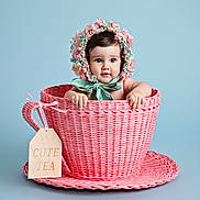Daisy joined the competition — help win amazing prizes! baby, blue_background, bow, child, cute, face, floral_bonnet, hands, hat, infant, photography, pink, playful, portrait, ribbon, saucer, studio, tag, teacup, woven