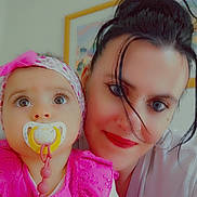 Négane participe au concours pour gagner de l'argent avec cette photo : baby, woman, child, pacifier, pink_dress, headband, indoor, portrait, face, person, closeup, smile, jewelry, piercing, hair, eyebrows, light, background, clothing, happy