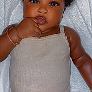 Mané a rejoint le concours — aidez-le/la à gagner de superbes lots ! baby, child, infant, curly_hair, onesie, bracelet, hand, face, skin, lying_down, white_blanket, cute, adorable, portrait, close_up, expression, person, young_child, sleepwear, indoor