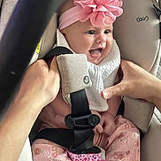Noelymar joined the competition — help win amazing prizes! baby, infant, car_seat, pink_flower, headband, hands, safety_harness, smiling, tongue_out, cute, clothing, patterned_pants, white_bib, pacifier, seatbelt, child, indoor, person, happy, close_up