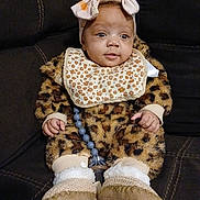 Zariyah is registered to the contest to win money with this photo: baby, infant, child, leopard_print, fuzzy_clothing, headband, bow, bib, booties, pacifier_clip, couch, indoor, seated, cute, adorable, portrait, clothing, soft_texture, happy, young