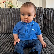 Mylan a rejoint le concours — aidez-le/la à gagner de superbes lots ! baby, child, blue_polo_shirt, jeans, black_shoes, couch, gray_couch, mirror, indoor, curious_expression, sitting, short_hair, casual_clothing, home_decor, furniture, portrait, young_child, pout, cute, person