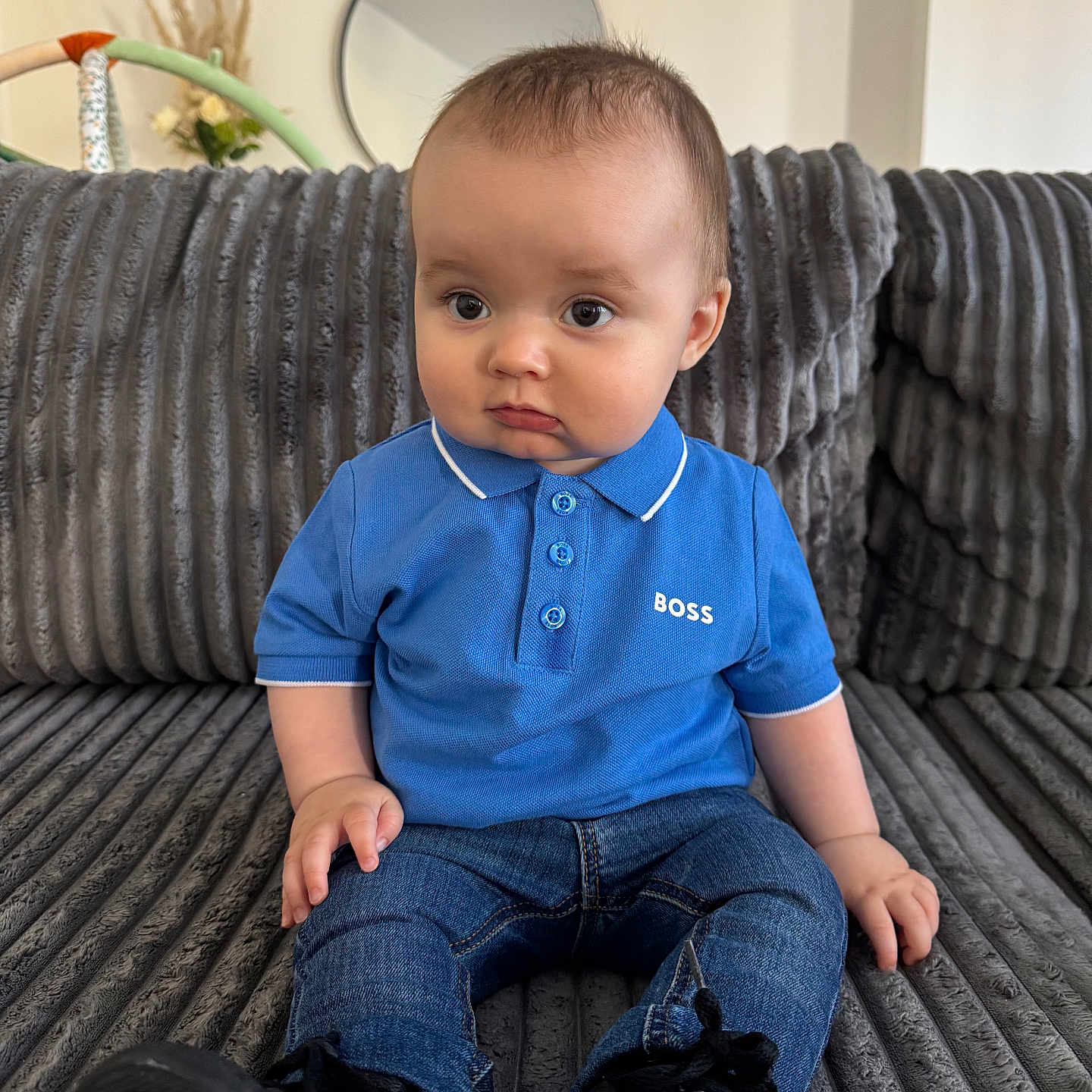 Mylan a rejoint le concours — aidez-le/la à gagner de superbes lots ! baby, black_shoes, blue_polo_shirt, casual_clothing, child, couch, curious_expression, cute, furniture, gray_couch, home_decor, indoor, jeans, mirror, person, portrait, pout, short_hair, sitting, young_child