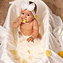 baby, infant, headband, bow, milk_bath, lemon, slice, blanket, tub, sitting, cute, curious, skin, playful, indoors, child, portrait, soft_texture, white_color, food