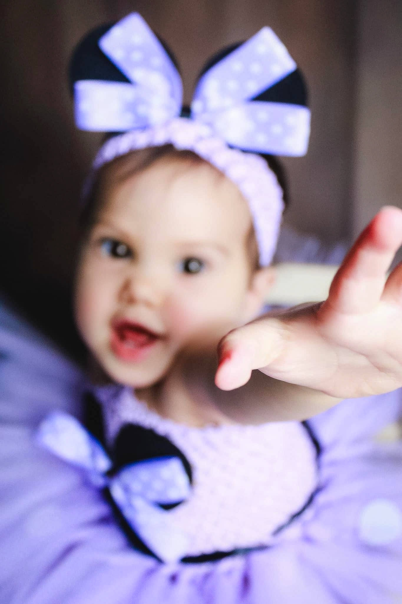 Lilou a rejoint le concours — aidez-le/la à gagner de superbes lots ! baby, baby_toddler_clothing, costume_hat, ear, eyelash, face, finger, flash_photography, gesture, hand, happy, head, headband, headgear, headpiece, person, pink, purple, skin, smile