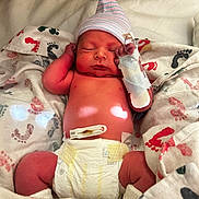 Houston is registered to the contest to win money with this photo: newborn, baby, diaper, blanket, hospital, hat, footprints, sleeping, medical_tape, monitor, infant, cute, child, resting, skin, human, bed, comfort, healthcare, swaddled