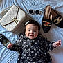 Ainoha is registered to the contest to win money with this photo: baby, infant, child, smiling, dress, black_dress, hair_bow, hair_clip, handbag, purse, white_bag, sunglasses, shoes, loafers, perfume, bed, bedding, lying_down, portrait, accessory