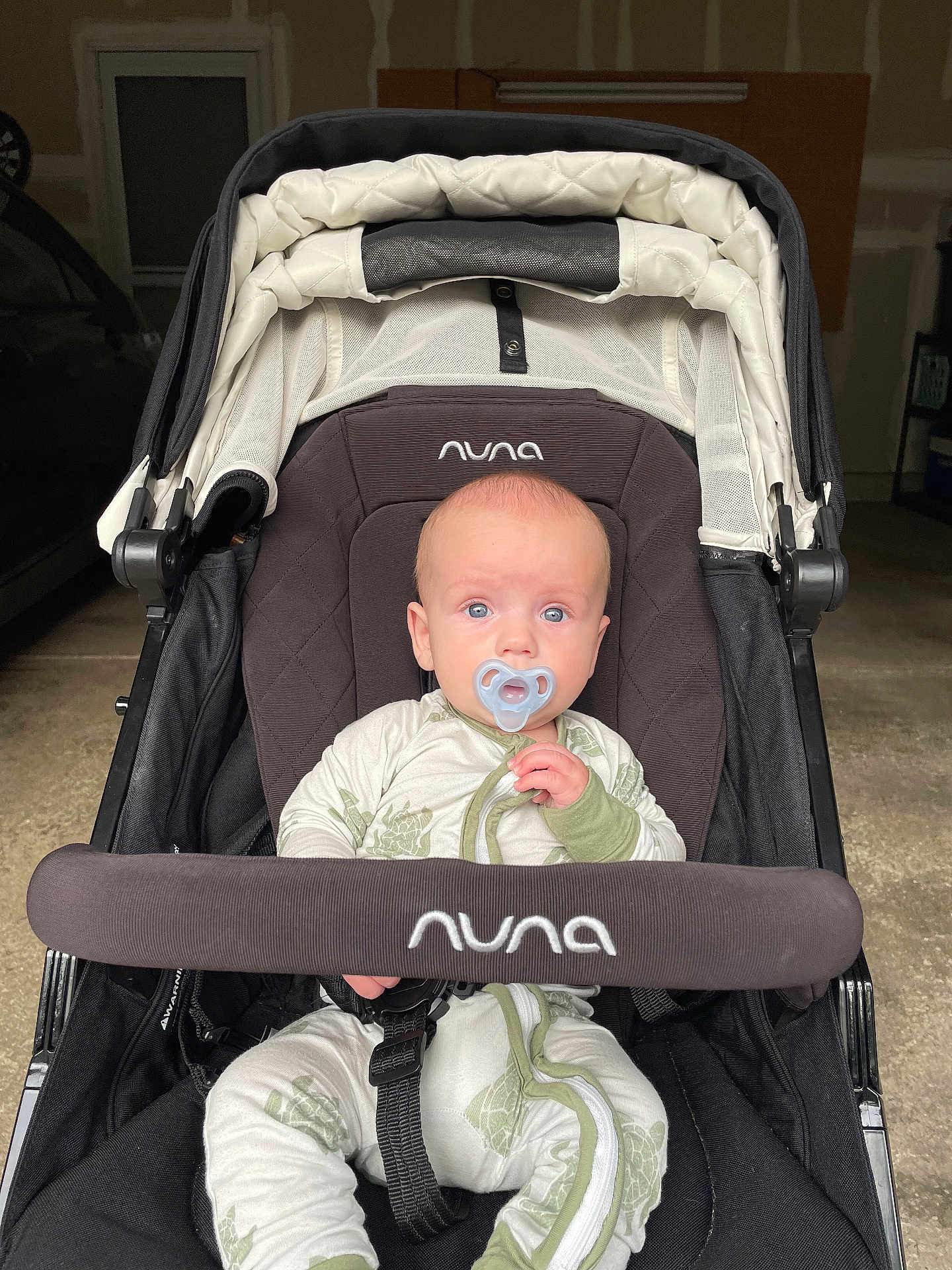 Jaxson joined the competition — help win amazing prizes! baby, pacifier, stroller, nuna, infant, clothing, face, blue_eyes, sitting, child, indoor, garage, seat_belt, fabric, person, young_child, cute, portrait, baby_clothes, transport