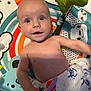 Jaxson is registered to the contest to win money with this photo: baby, child, infant, play_mat, toy, blanket, smile, face, blue_eyes, shirtless, colorful, animal_print, crab_print, yellow_toy, happy, indoors, cute, lying_down, cheerful, curious