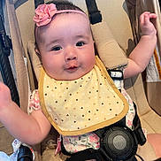 Leah joined the competition — help win amazing prizes! baby, infant, child, stroller, car_seat, headband, flower, bib, clothing, cute, smiling, happy, arm, seatbelt, indoor, closeup, person, face, skin, expression