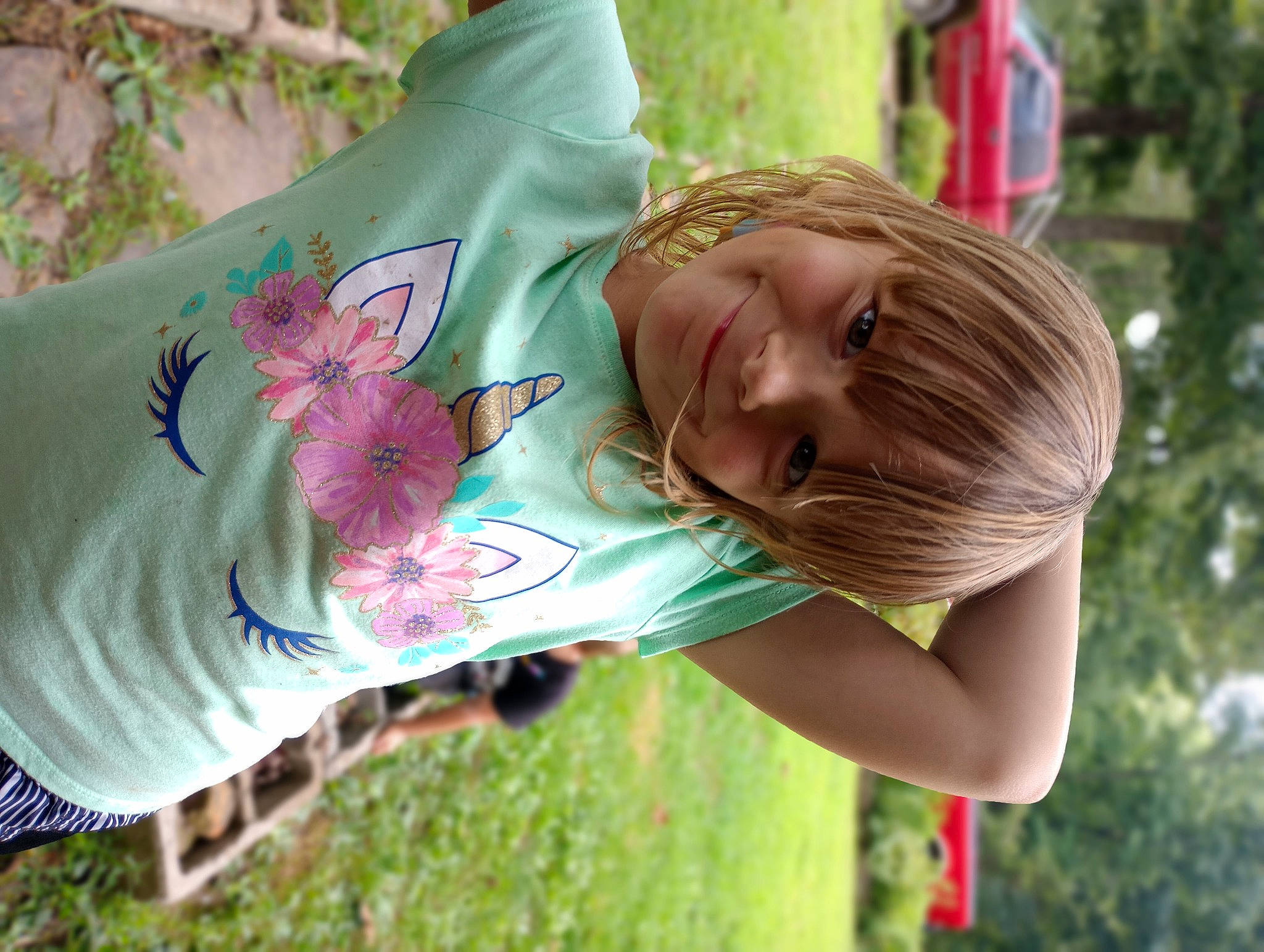 Alexis is registered to the contest to win money with this photo: arm, botany, child, facial_expression, grass, green, hairstyle, hand, happy, joint, joy, leaf, leisure, neck, people_in_nature, person, plant, shoulder, sleeve, smile